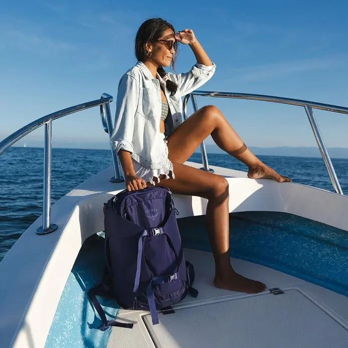 Osprey Sojourn Porter 30L (2026) - travel lifestyle on a boat, shown in Deep Fig