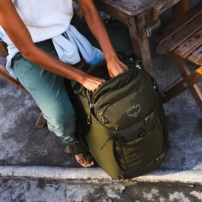 Osprey Sojourn Porter 46L (2026) - opening the pack while traveling, shown in Moss Green