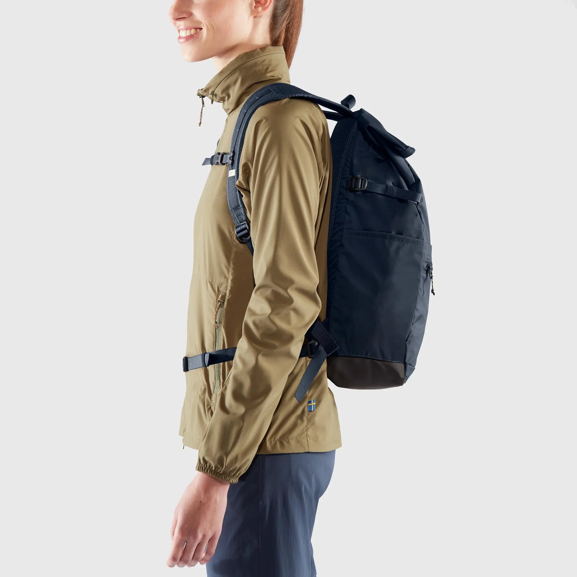 Fjallraven High Coast Foldsack 24, side view worn by a model, shown in Navy; shared feature image