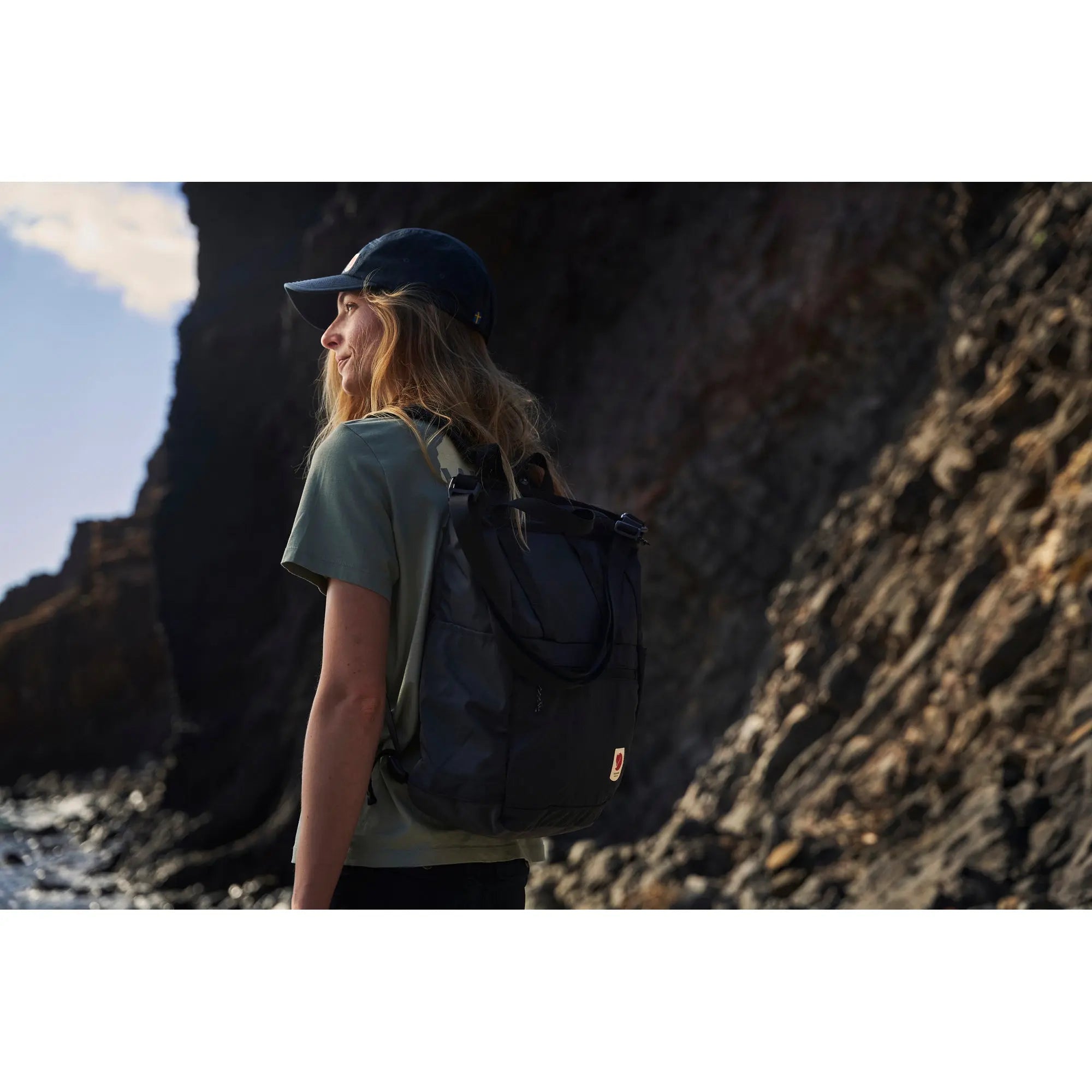 Fjallraven High Coast Totepack, backpack carry outdoors by a rocky coastline, shown in navy; shared feature image
