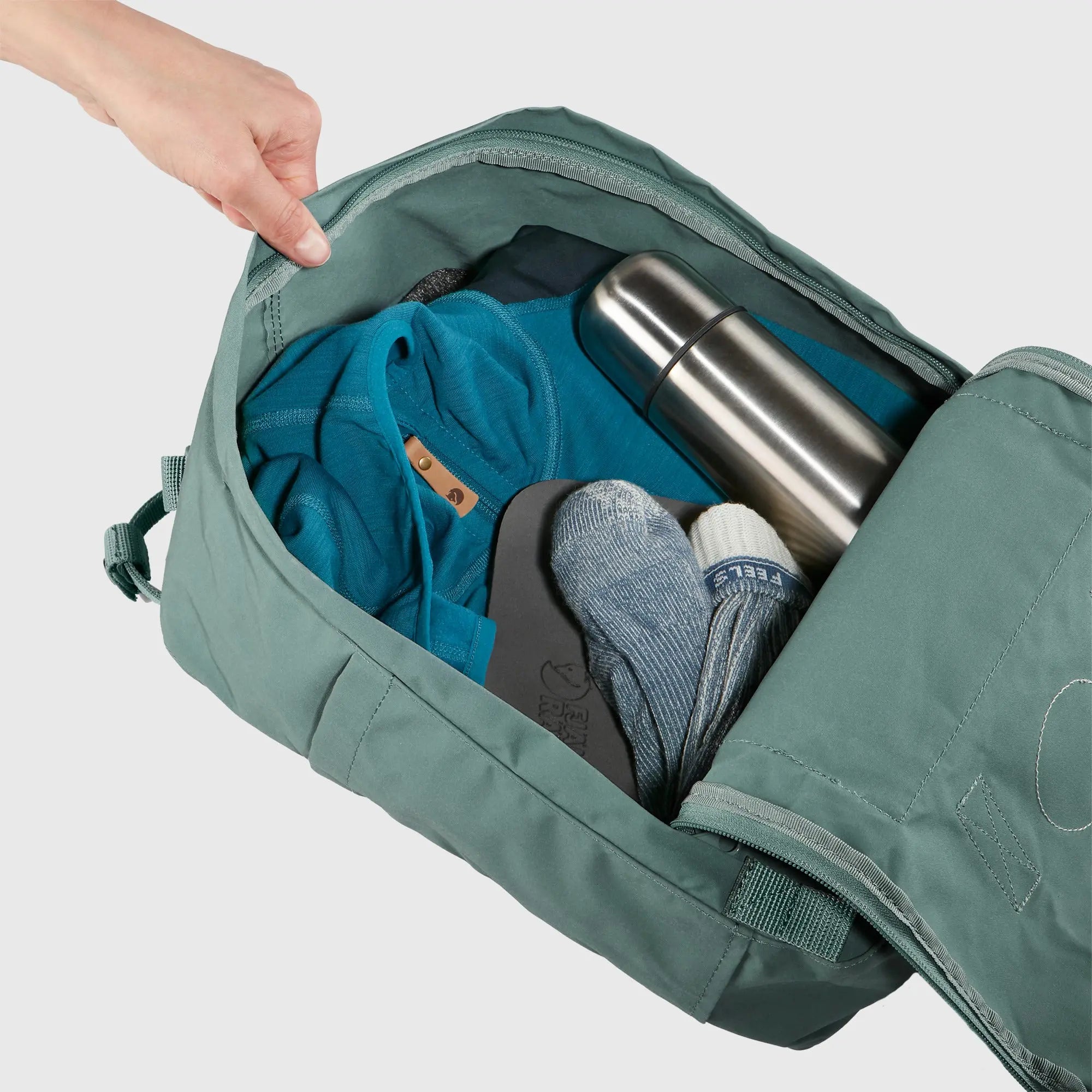 Fjallraven Kanken Backpack, open main compartment packed with essentials, shown in Frost Green; shared feature image