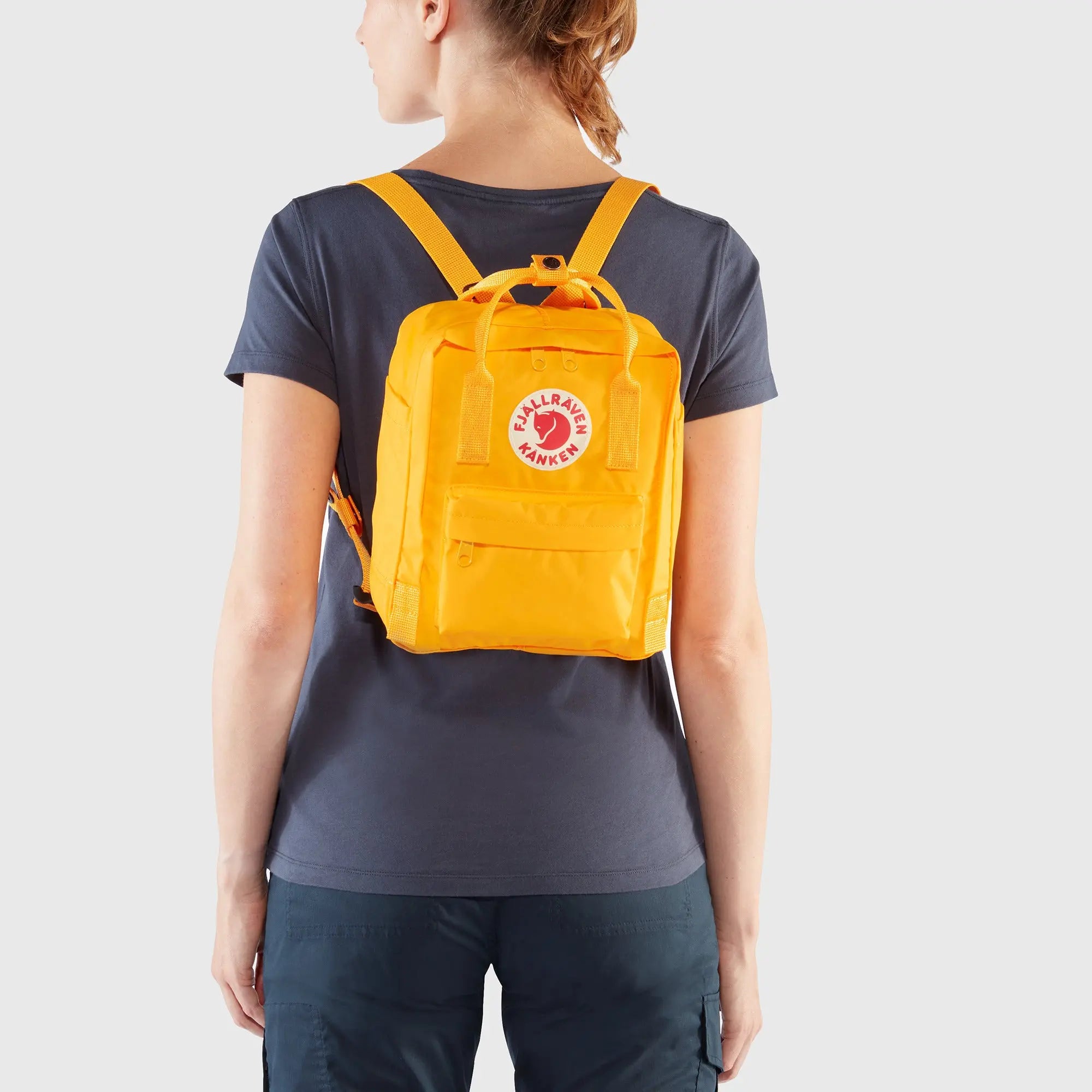 Fjallraven Kanken Mini Backpack, rear backpack fit on a model, shown in Warm Yellow; shared feature image