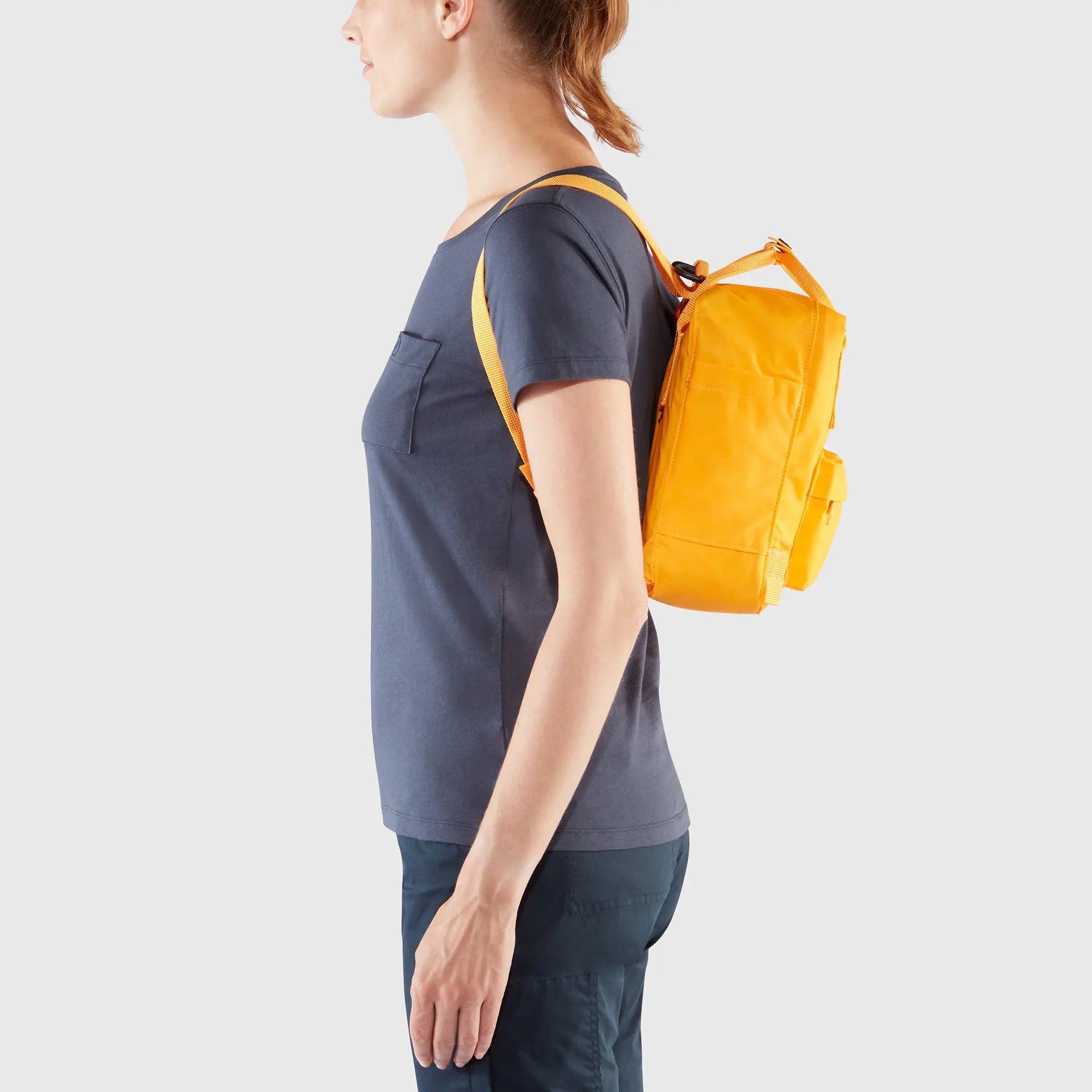 Fjallraven Kanken Mini Backpack, side backpack fit on a model, shown in Warm Yellow; shared feature image