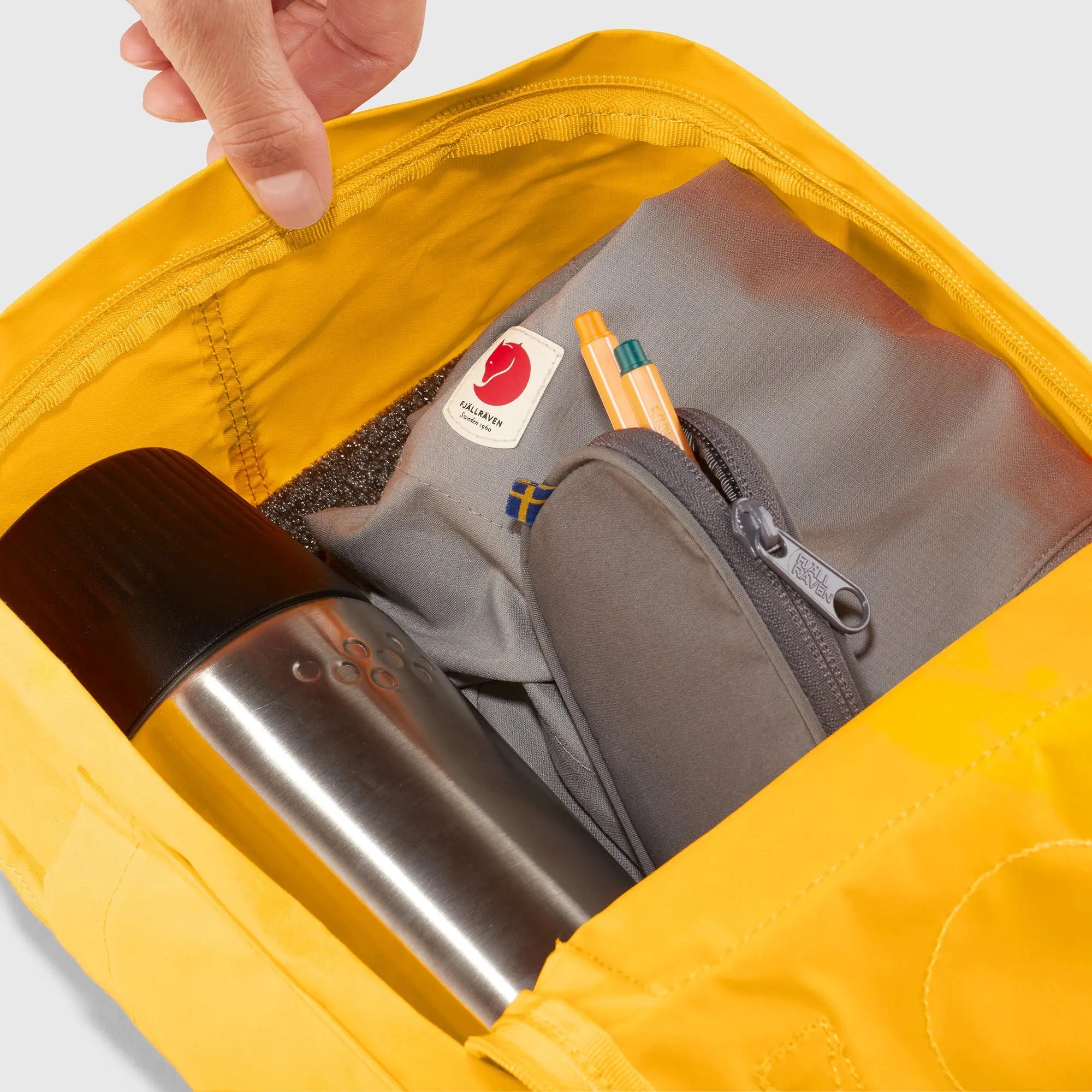 Fjallraven Kanken Mini Backpack, open main compartment packed with essentials, shown in Warm Yellow; shared feature image