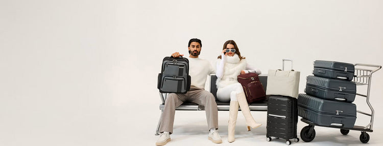 man and woman sitting with luggage