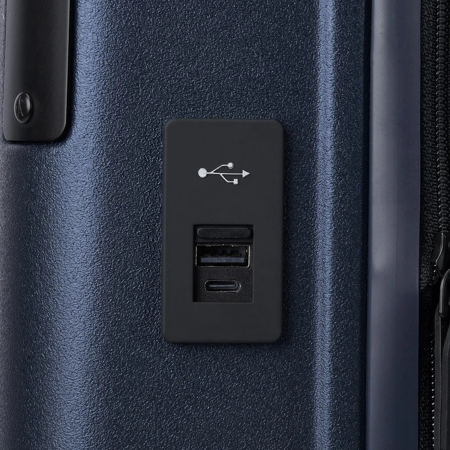 macro detail view of the external usb-a and usb-c charging ports on the travelpro platinum elite compact carry-on hardside spinner in aviator navy, highlighting the integrated power connectivity.