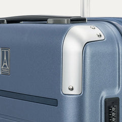 close-up detail of the travelpro platinum elite compact carry-on hardside spinner in dark sky blue, highlighting the polished aluminum corner armor and the integrated tsa-approved combination lock.