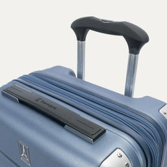 close-up detail of the travelpro platinum elite compact carry-on hardside spinner in dark sky blue, showing the low-profile top carry handle with the travelpro logo and the sturdy powerscope lite telescoping handle.