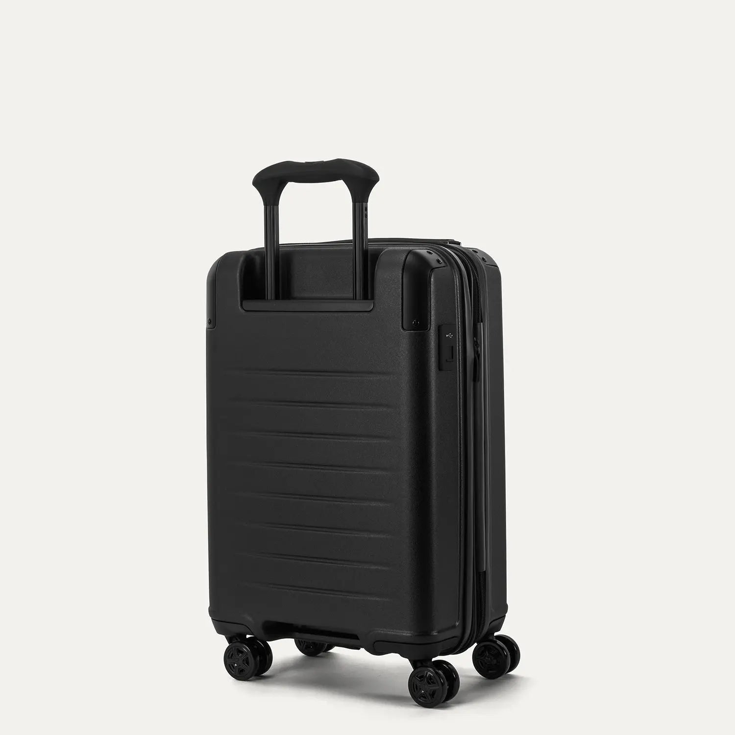Rear angled view of the Travelpro Platinum Elite Compact Carry-On Hardside Spinner in Shadow Black, showing the durable polycarbonate shell, the PowerScope Lite telescoping handle, and the dual spinner wheels.