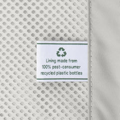 Macro detail of the ECOFAB™ interior lining on the Travelpro Platinum Elite Compact Carry-On Hardside Spinner in Aviator Navy, featuring a tag that reads "Lining made from 100% post-consumer recycled plastic bottles."