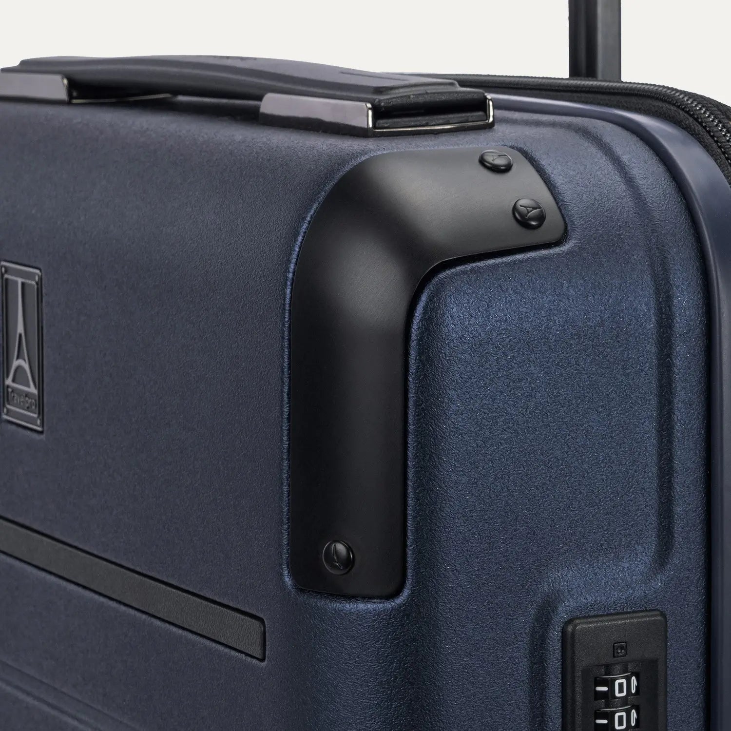 close-up detail of the travelpro platinum elite compact carry-on hardside spinner in aviator navy, highlighting the zinc-alloy corner armor and the integrated tsa-approved combination lock.