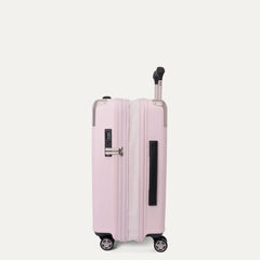Side profile view of the light pink Travelpro Platinum Elite Next Gen Powder Pink Suitcase, showing the hardshell spinner resting upright with an integrated TSA combination lock, side handle, and multi-directional wheels against a clean off-white background.