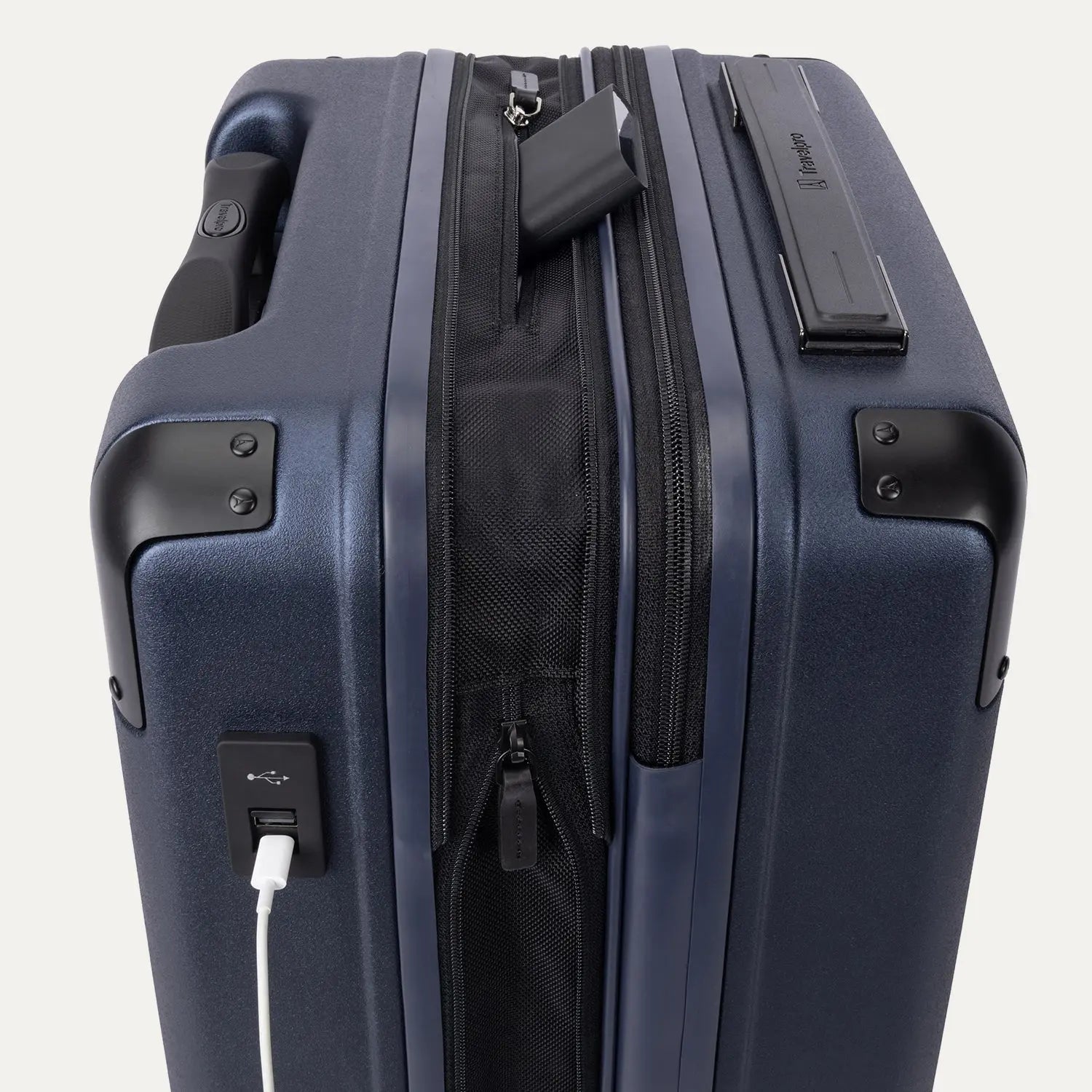close-up of the external usb-a and usb-c charging ports on the travelpro platinum elite compact carry-on hardside spinner in aviator navy, showing a power bank tucked into the dedicated battery sleeve within the expansion gusset.