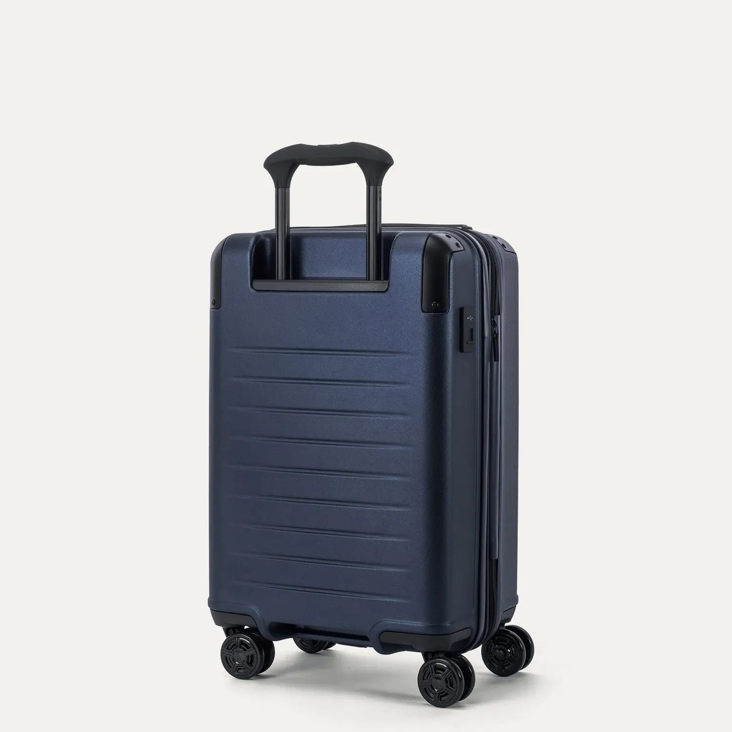 Rear angled view of the Travelpro Platinum Elite Carry-On Hardside Spinner in Aviator Navy, showing the durable polycarbonate shell, the PowerScope Lite telescoping handle, and the dual spinner wheels.