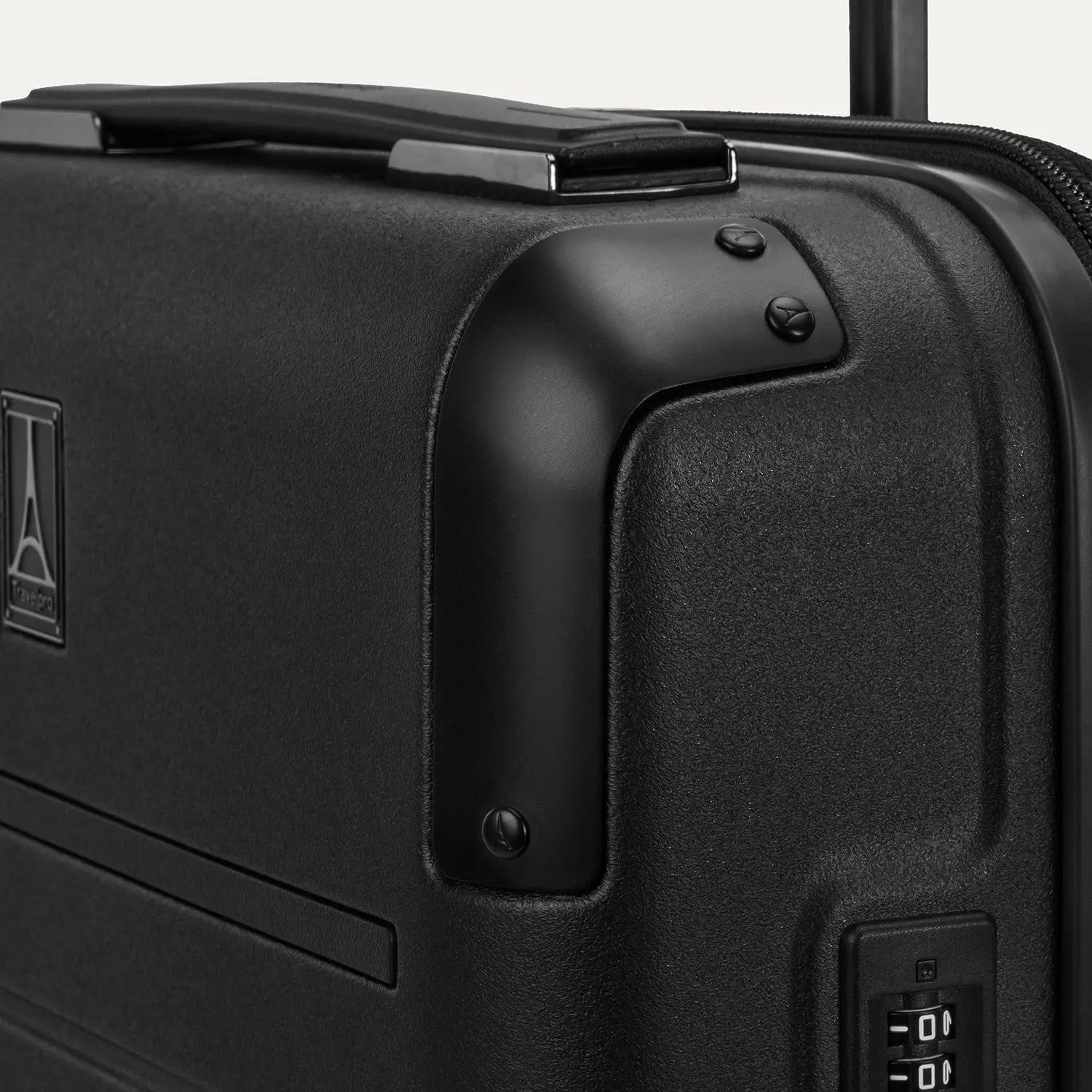 Close-up of the Platinum Elite Carry-On Hardside Spinner in Jet Black showing the polished aluminum corner armor, the integrated TSA-approved combination lock, and the rubberized Contour Grip handle against a light gray background.