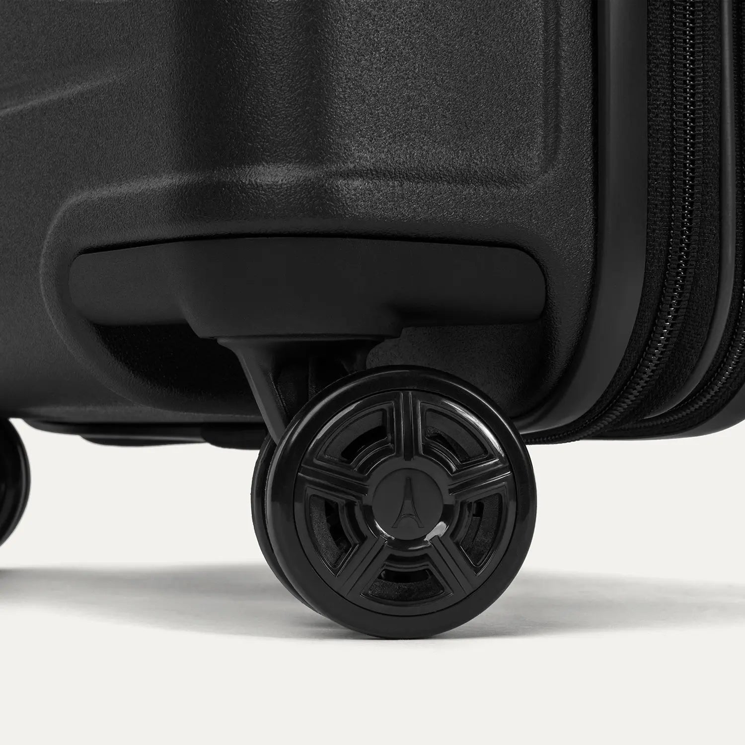 Close-up of the high-performance spinner wheels on the Travelpro Platinum Elite Carry-On Hardside Spinner in Jet Black, featuring self-aligning MagnaTrac® technology for effortless 360-degree mobility.