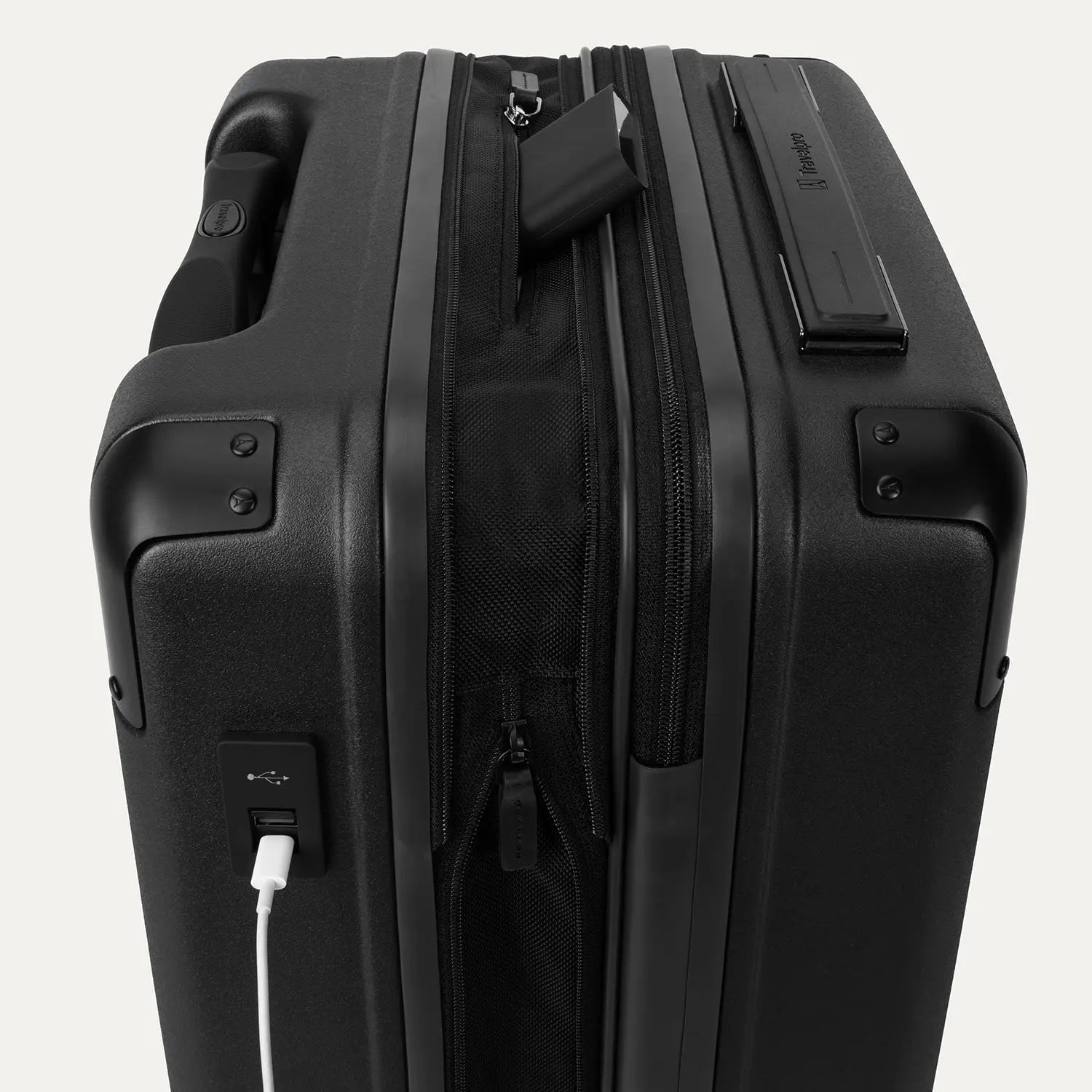 Close-up of the external charging ports on the Travelpro Platinum Elite Carry-On Hardside Spinner in Jet Black, showing a cable plugged into the USB-A port next to the USB-C port and the discreet battery pocket.