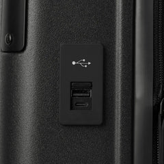 Macro detail view of the external USB-A and USB-C charging ports on the Travelpro Platinum Elite Carry-On Hardside Spinner in Jet Black, highlighting the integrated power connectivity for mobile devices.