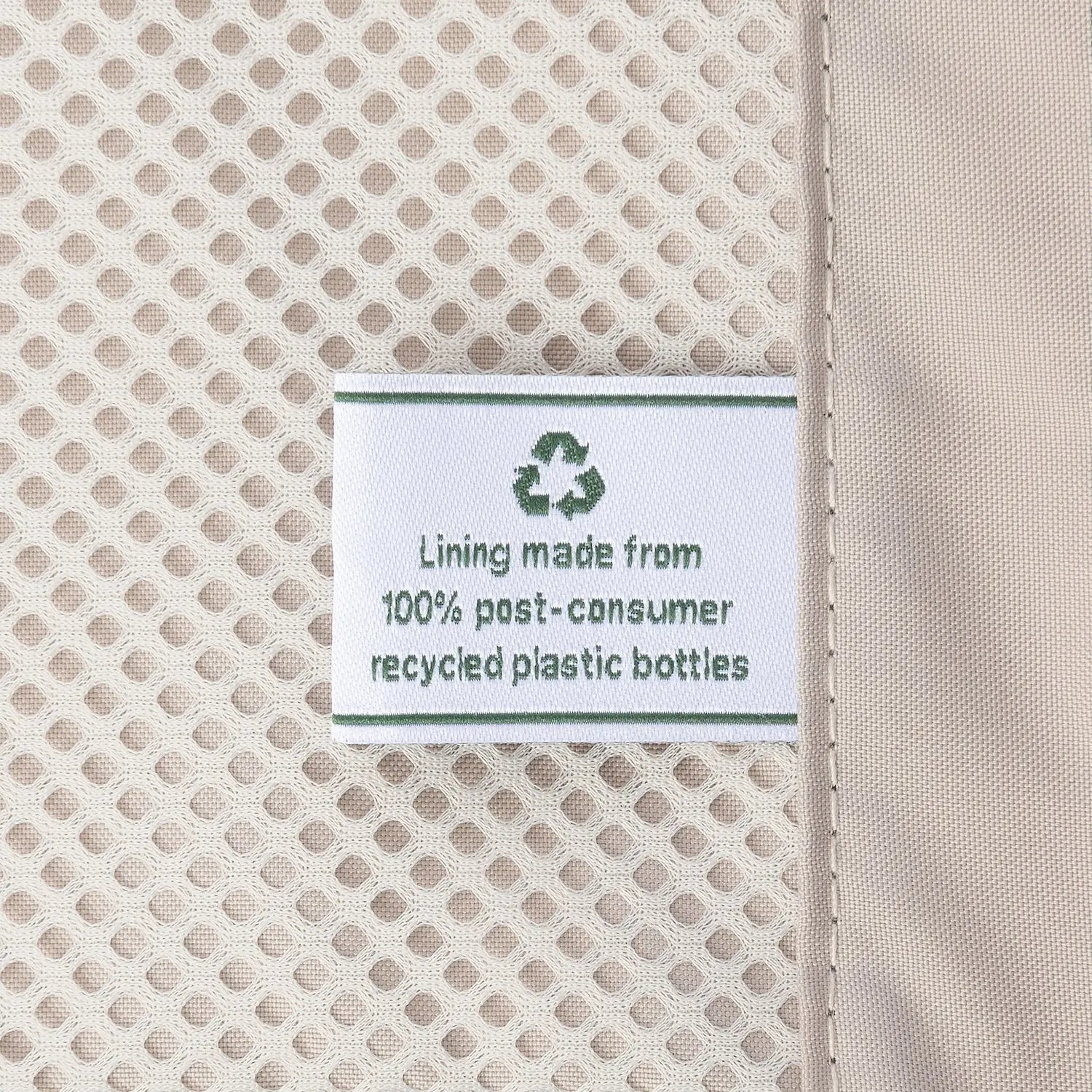 Close-up detail of the ECOFAB™ lining inside the Travelpro Platinum Elite Carry-On Hardside Spinner in Dark Sky Blue, showing a white fabric label that reads "Lining made from 100% post-consumer recycled plastic bottles" with a green recycling symbol.