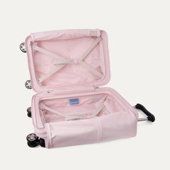 Open interior view of the light pink Travelpro Platinum Elite Next Gen Powder Pink Suitcase, showing the main packing compartment with X-shaped compression straps, a zippered mesh lid pocket, and a blue Travelpro brand label against a clean off-white background.