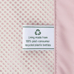 Close-up view of the ECOFAB lining inside the Travelpro Platinum Elite Next Gen Powder Pink Suitcase, featuring a white fabric label that reads "Lining made from 100% post-consumer recycled plastic bottles" with a green recycling symbol against the pink mesh interior.
