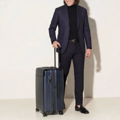 Front view of the Travelpro Platinum Elite Medium Check-In Hardside Spinner in Aviator Navy, featuring a durable polycarbonate shell, polished aluminum corner armor, and genuine leather trim.