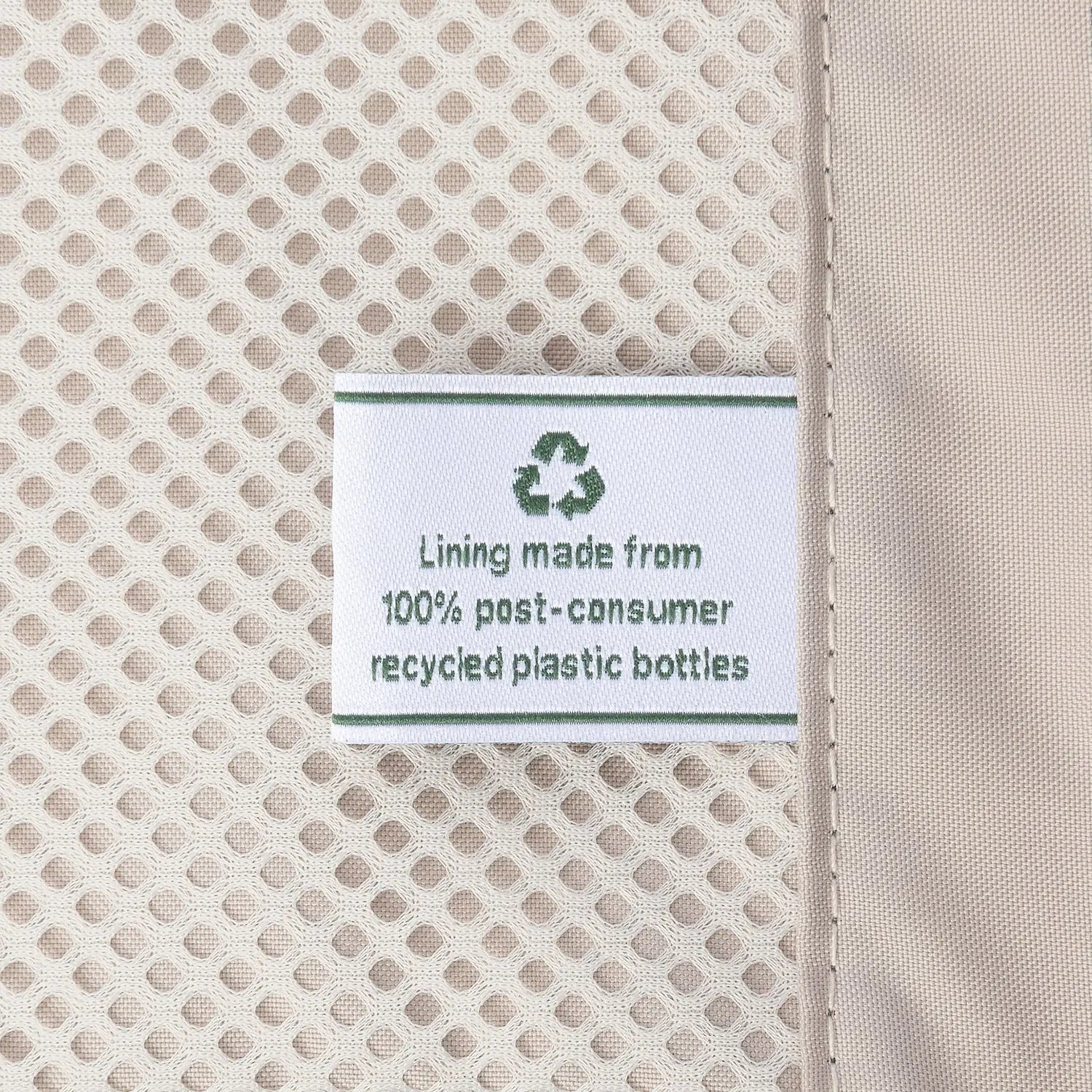 Close-up detail of the ECOFAB™ lining inside the Travelpro Platinum Elite Medium Check-In Hardside Spinner, showing a white fabric label that reads "Lining made from 100% post-consumer recycled plastic bottles" with a green recycling symbol.