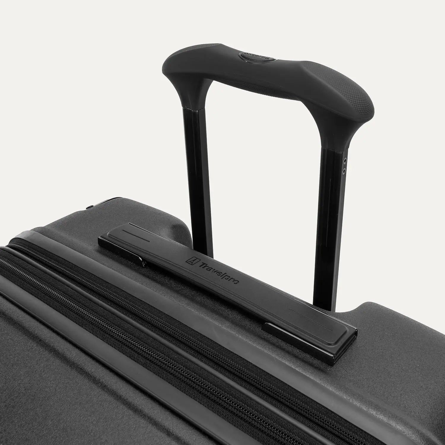Close-up of the Travelpro Platinum Elite Medium Check-In Hardside Spinner in Jet Black, featuring the multi-stop PowerScope Lite handle and the sleek, low-profile top carry handle with the Travelpro logo.