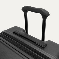 Close-up of the Travelpro Platinum Elite Medium Check-In Hardside Spinner in Jet Black, featuring the multi-stop PowerScope Lite handle and the sleek, low-profile top carry handle with the Travelpro logo.
