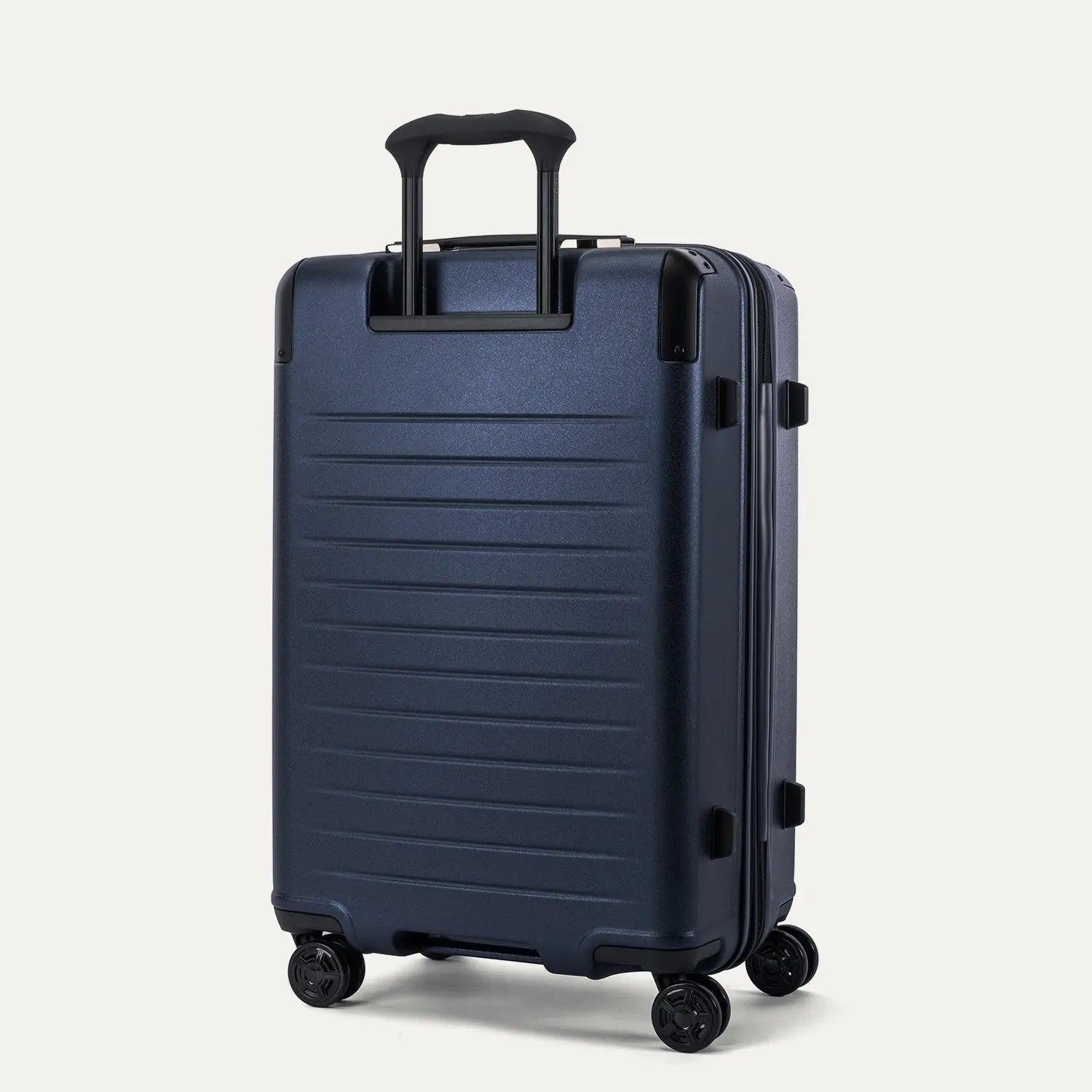 Rear view of the Travelpro Platinum Elite Medium Check-In Hardside Spinner in Aviator Navy, showing the durable, textured polycarbonate shell and the sturdy PowerScope Lite telescoping handle.