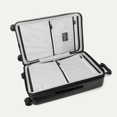 Interior view of the Travelpro Platinum Elite Medium Check-In Hardside Spinner in Jet Black, featuring dual zippered divider panels and the ECOFAB™ lining made from 100% recycled plastic bottles.