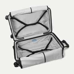 Fully open interior packing view of the Travelpro Platinum Elite Medium Check-In Hardside Spinner in Jet Black, showing the main compartment with adjustable hold-down straps and the ECOFAB™ lining.
