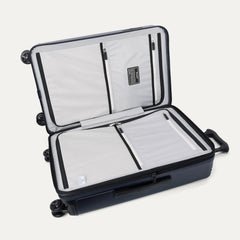 Interior packing view of the Travelpro Platinum Elite Medium Check-In Hardside Spinner in Aviator Navy, featuring dual zippered divider panels and the ECOFAB™ lining made from 100% recycled plastic bottles.