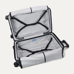Fully open interior packing view of the Travelpro Platinum Elite Medium Check-In Hardside Spinner in Aviator Navy, showing the main compartment with adjustable hold-down straps and the ECOFAB™ lining.