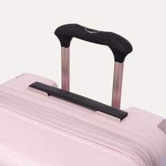 Close-up of the Travelpro Platinum Elite Medium Check-In Hardside Spinner in Powder Pink, highlighting the multi-stop PowerScope Lite telescoping handle, the rubberized Contour Grip, and the top carry handle against a clean off-white background.