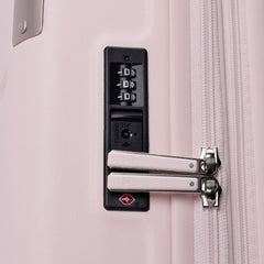 Close-up of the Travelpro Platinum Elite Medium Check-In Hardside Spinner in Powder Pink, highlighting the integrated TSA-approved combination lock, dual zipper pulls, and side zipper trim against a clean off-white background.