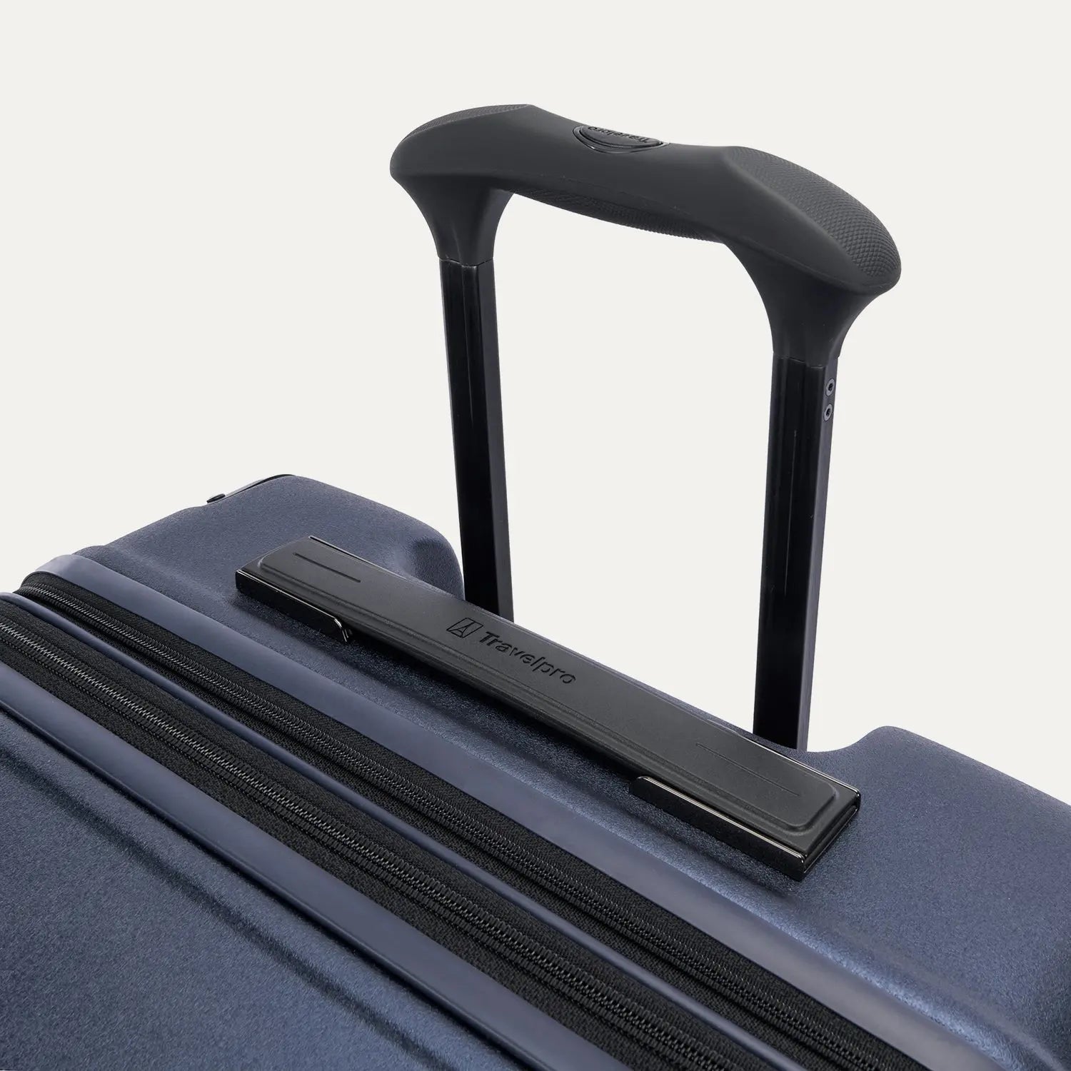 Close-up of the Travelpro Platinum Elite Medium Check-In Hardside Spinner in Aviator Navy, featuring the multi-stop PowerScope Lite handle and the sleek, low-profile top carry handle with the Travelpro logo.