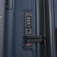 Close-up detail of the Travelpro Platinum Elite Medium Check-In Hardside Spinner in Aviator Navy, showing the integrated TSA-approved combination lock and secure zipper pulls on the polycarbonate shell.