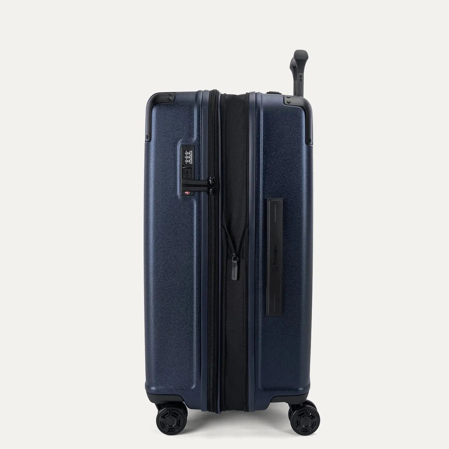 Side profile view of the Travelpro Platinum Elite Medium Check-In Hardside Spinner in Aviator Navy, showing the zippered expansion feature that provides 2 inches of additional packing capacity.