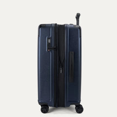Side profile view of the Travelpro Platinum Elite Medium Check-In Hardside Spinner in Aviator Navy, showing the zippered expansion feature that provides 2 inches of additional packing capacity.