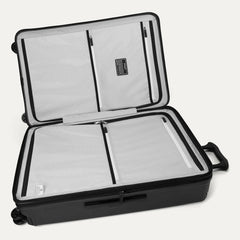 Interior view of the Travelpro Platinum Elite Large Check-In Hardside Spinner in Jet Black, featuring dual zippered divider panels and the ECOFAB™ lining made from recycled plastic bottles.