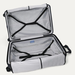 Fully open interior packing view of the Travelpro Platinum Elite Large Check-In Hardside Spinner in Aviator Navy, showing the main compartment with adjustable hold-down straps and the ECOFAB lining.